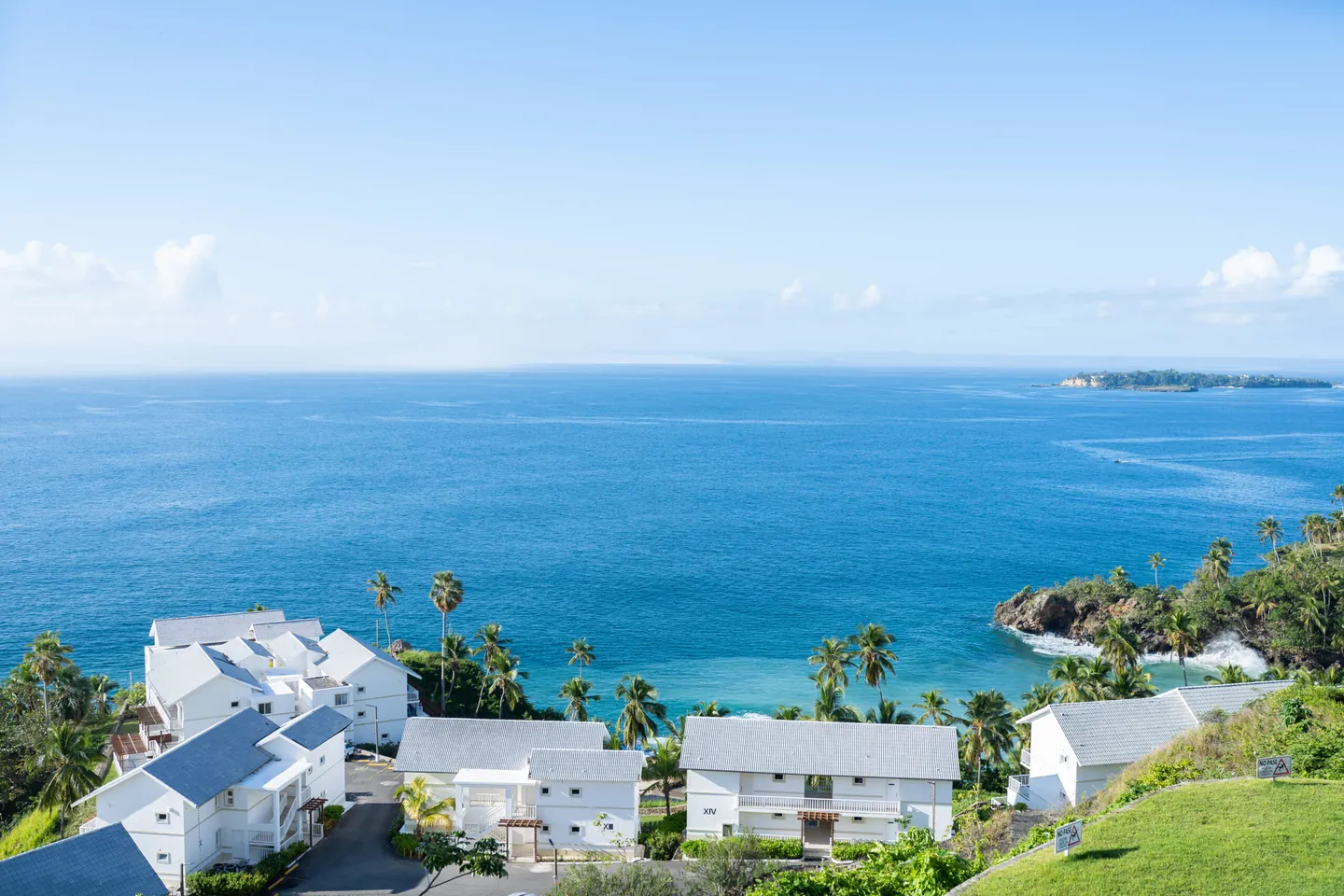 Aerial view of Vista Mare Samaná: white residence buildings on the green hill above the bay